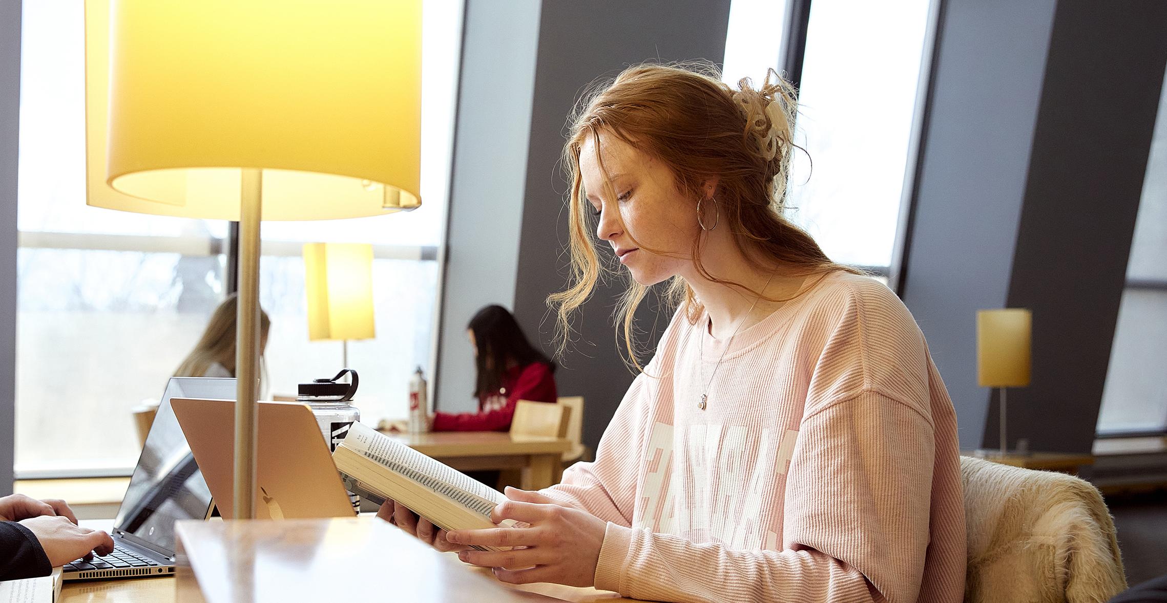 A student reads in Hedberg Library. 